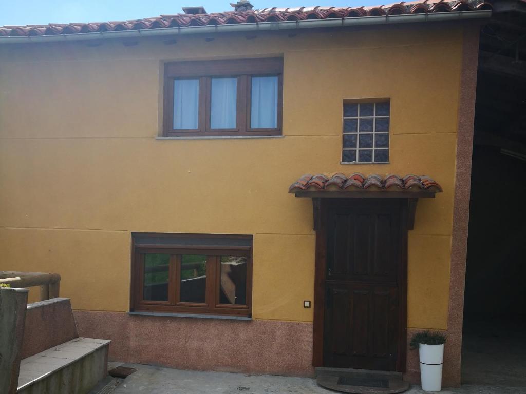 une maison jaune avec une porte et une fenêtre dans l'établissement Casa Nueva, à Salas