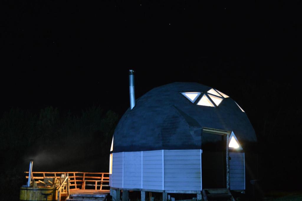 a large dome building with a light on it at night at domoschiloe in Ancud