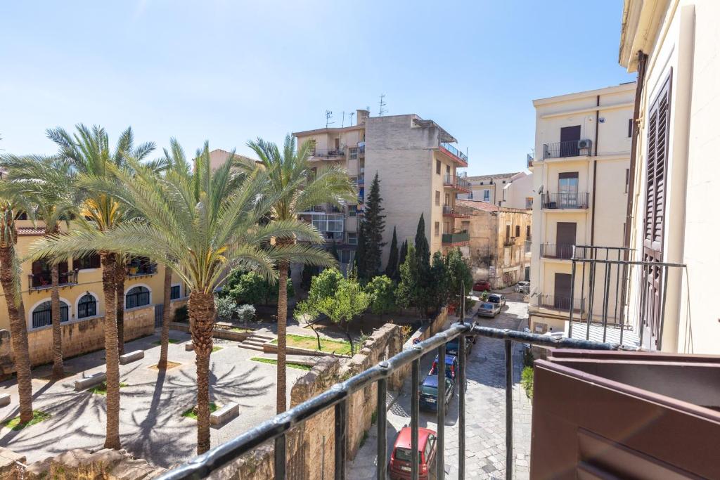 Blick auf eine Straße mit Palmen und Gebäuden in der Unterkunft Il Sonno dei Giusti Apartment by DomuSicily in Palermo