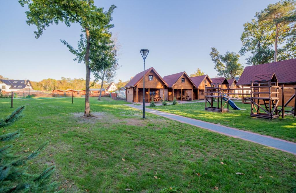 a park with a row of houses and a playground at Osada nad Dziwną domki nad morzem in Dziwnów