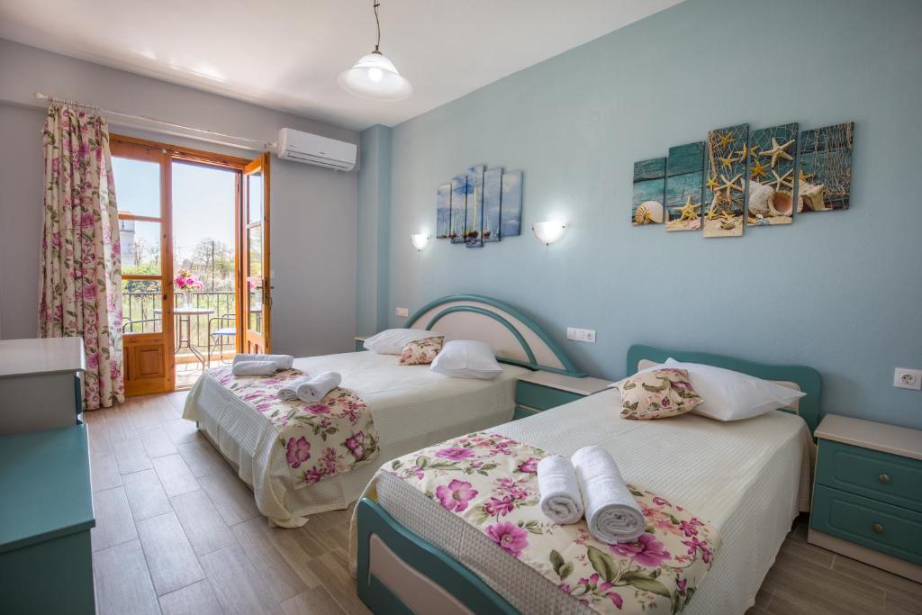 2 camas en una habitación con paredes azules en Villa Sotiria Lux, en Limenaria