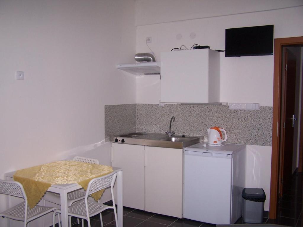 eine kleine Küche mit einem Tisch und einem Waschbecken in der Unterkunft Mitrans in Hradec Králové
