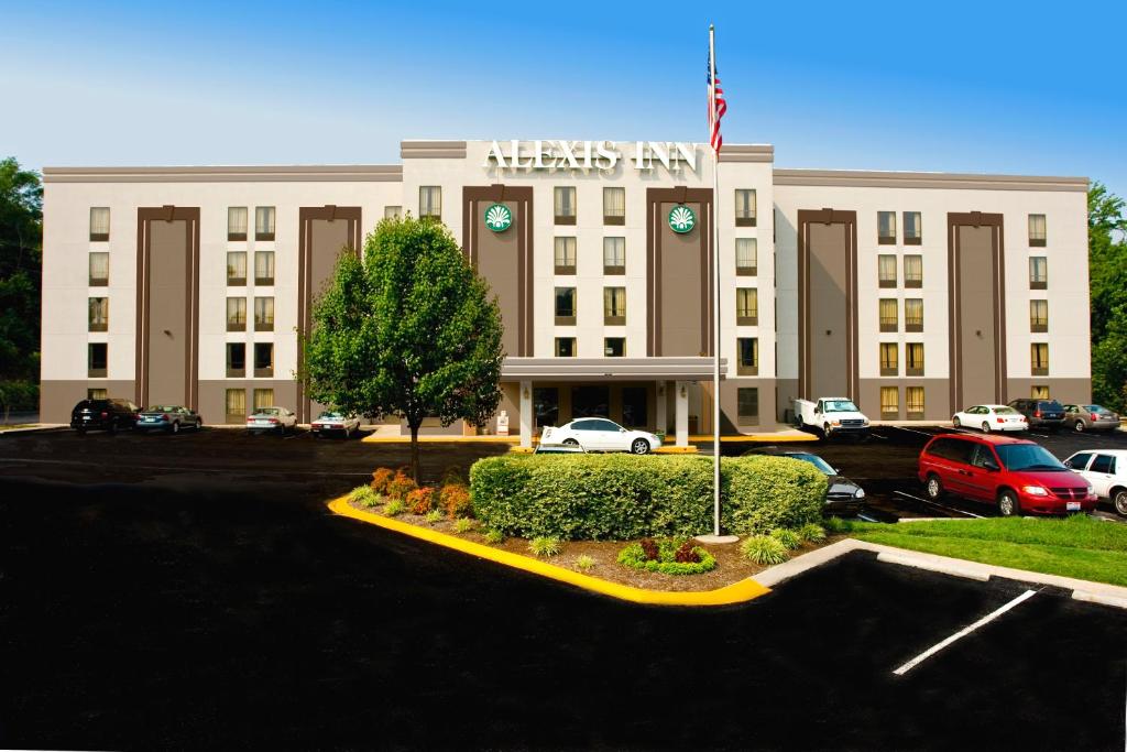 un edificio blanco con una bandera americana delante de él en Alexis Inn and Suites Hotel, en Nashville