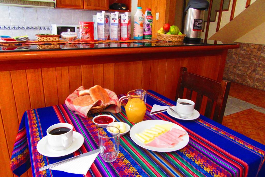 a table with breakfast foods and drinks on it at Hospedaje Kamila in Cusco