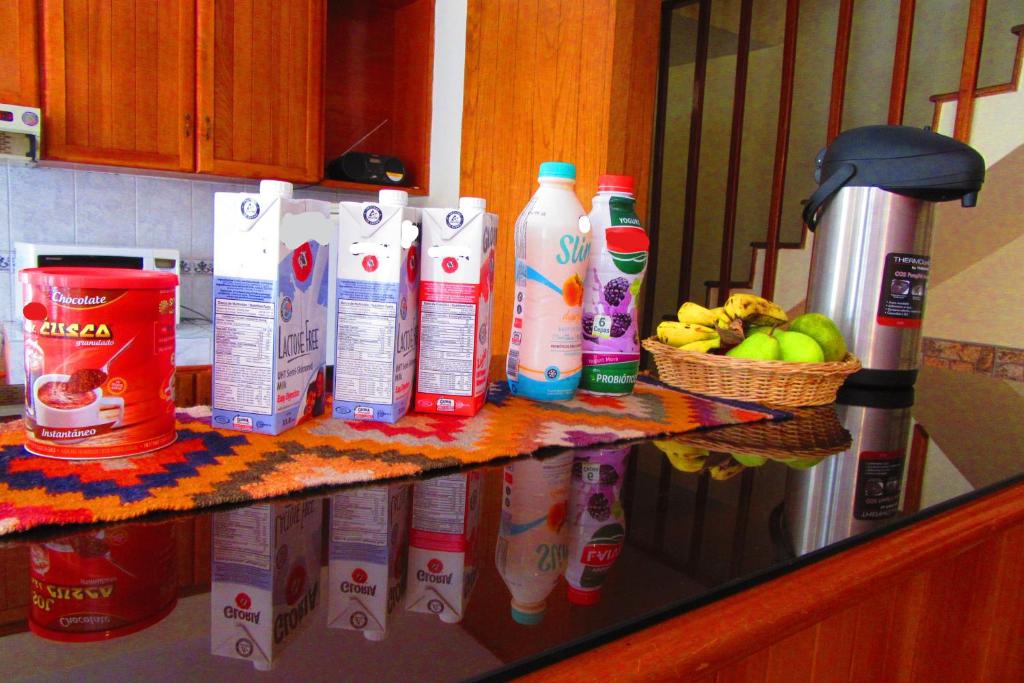 a counter with several bottles of milk and a basket of fruit at Hospedaje Kamila in Cusco