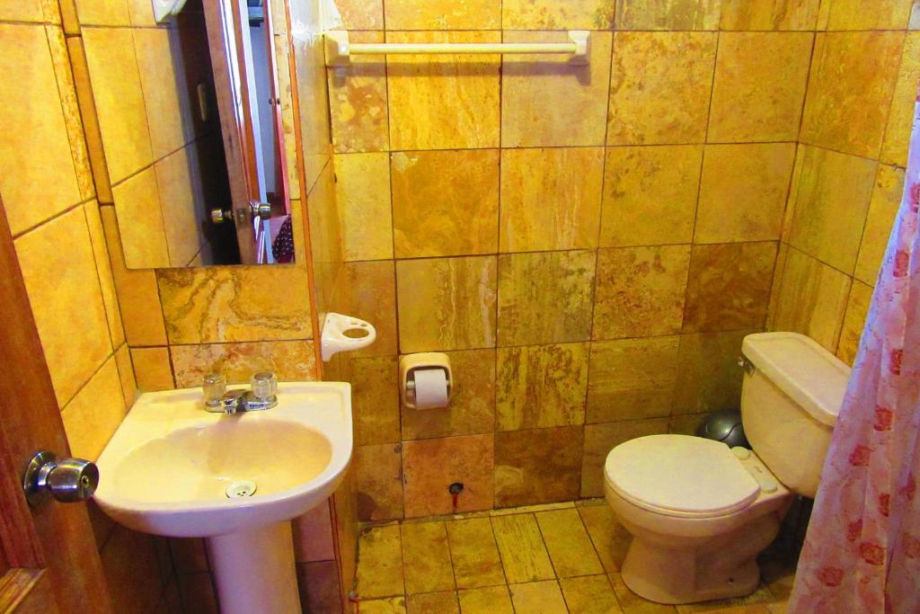 a small bathroom with a sink and a toilet at Hospedaje Kamila in Cusco