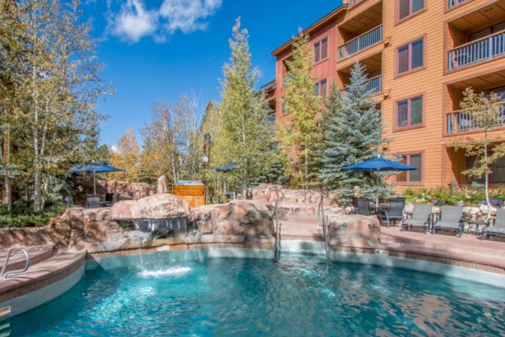 a swimming pool with a waterfall in a resort at River Run Village in Keystone