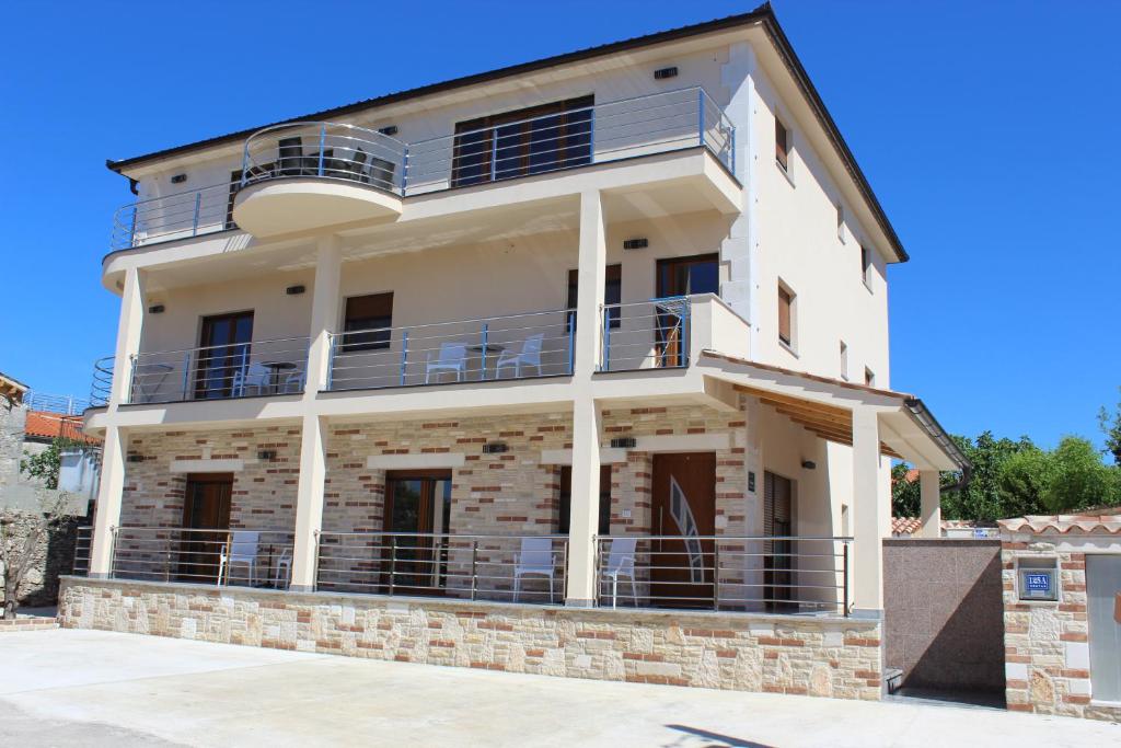 a large white building with balconies on it at Medulinka apartments in Medulin