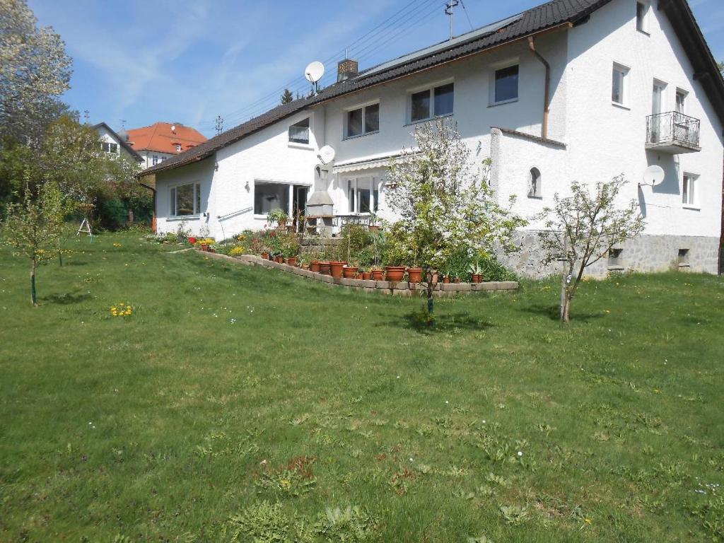 a white house with a yard in front of it at Ferienwohnung Casa MIA in Spiegelau