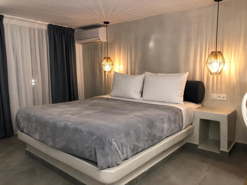 a bedroom with a large bed with two lights on it at Galatia Villas in Fira