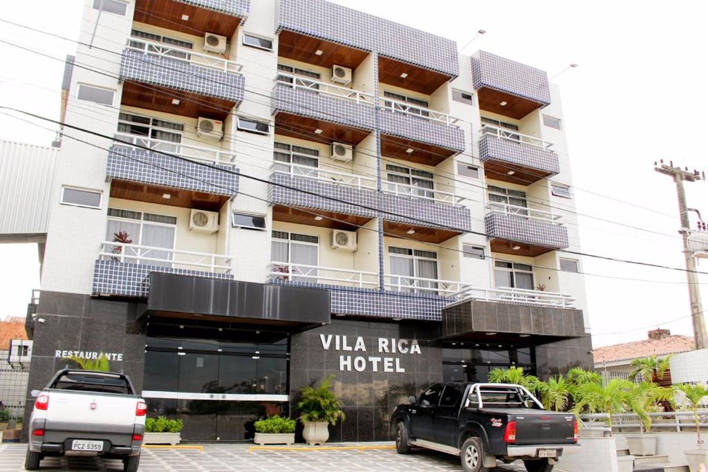 un hotel con dos camiones estacionados frente a él en Vila Rica Hotel Caruaru, en Caruaru