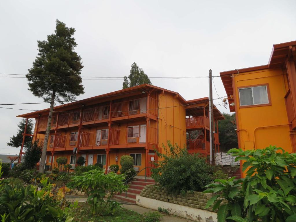 ein orangefarbenes Gebäude mit einem Baum davor in der Unterkunft Carquinez Inn in Vallejo