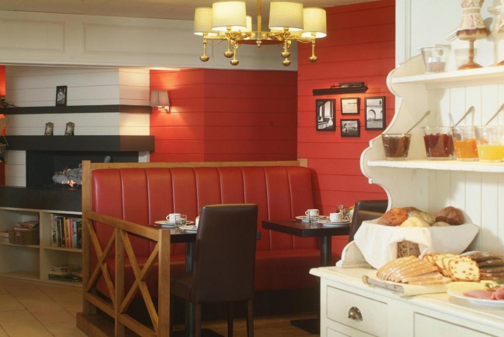 um restaurante com paredes vermelhas e uma mesa com comida em Hotel Internos em De Haan