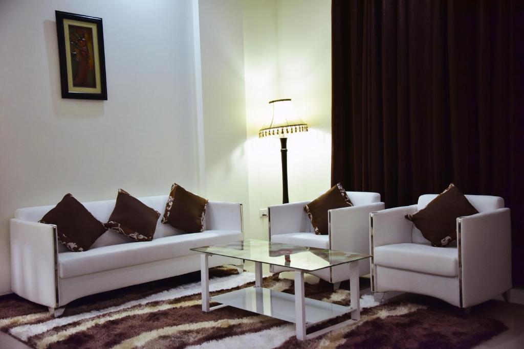 a living room with two couches and a coffee table at Hotel Blue Sapphire in Dar es Salaam