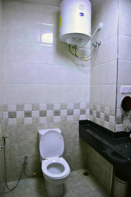 a bathroom with a toilet and a water tank at Hotel Blue Sapphire in Dar es Salaam