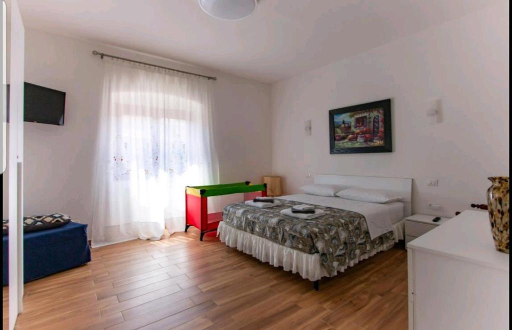 Schlafzimmer mit einem Bett, einem Tisch und einem Fenster in der Unterkunft Rina's House La Spezia in La Spezia