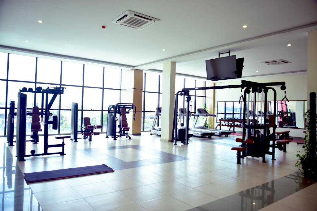 a gym with several tread machines and a flat screen tv at Hotel Blue Sapphire in Dar es Salaam