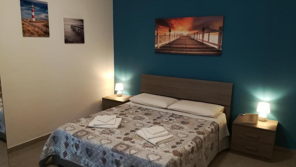 sypialnia z łóżkiem i niebieską ścianą w obiekcie Bed Cafe w Syrakuzach
