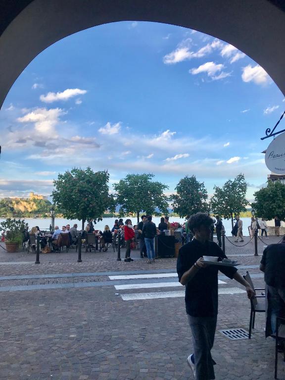 a man walking through an arch in a park at Il Giardino Segreto Arona, Charming Apartments in Arona
