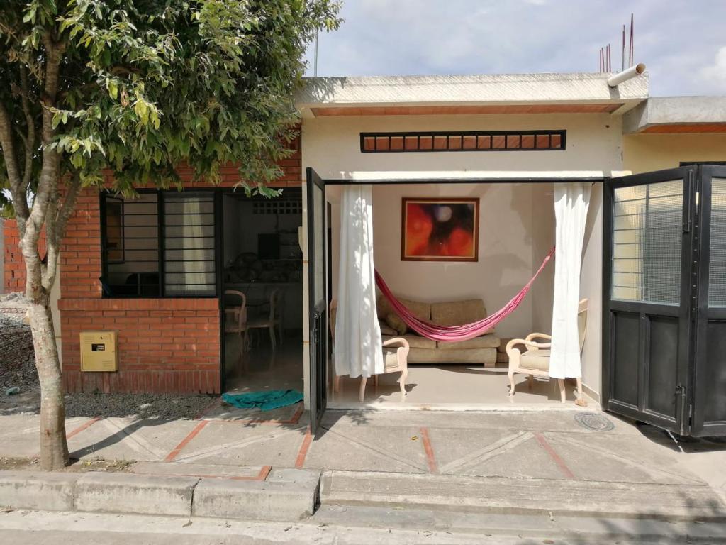 a house with a patio with a hammock in it at Villas de Santa Ana in Guamo