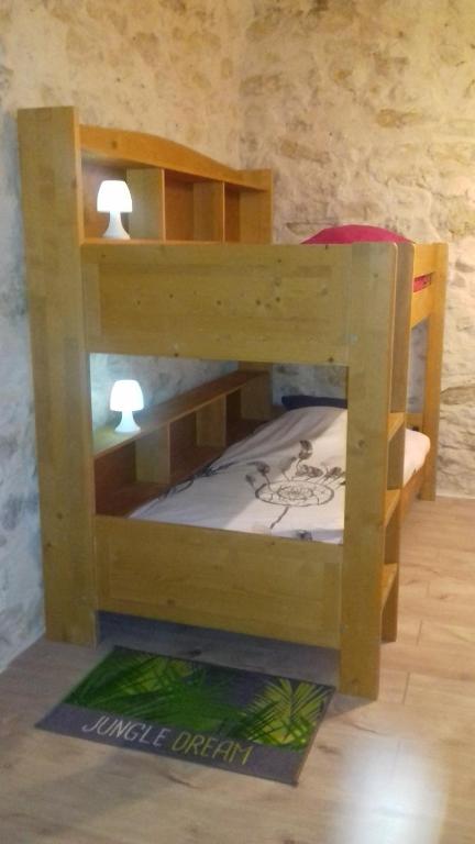 ein Etagenbett aus Holz in einem Zimmer in der Unterkunft Le Pigeonnier du Château in Saint-Victor-de-Malcap