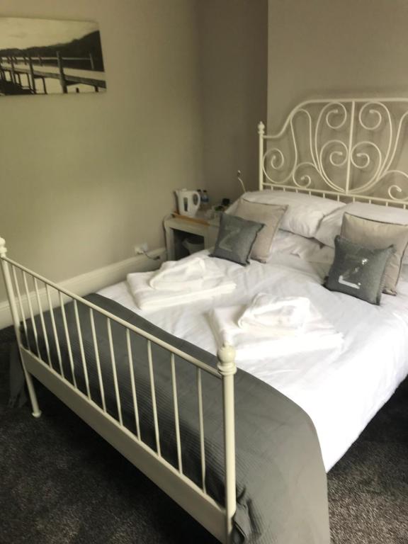 a bed with white sheets and pillows in a bedroom at Two Little Ducks Guesthouse in Ellesmere Port