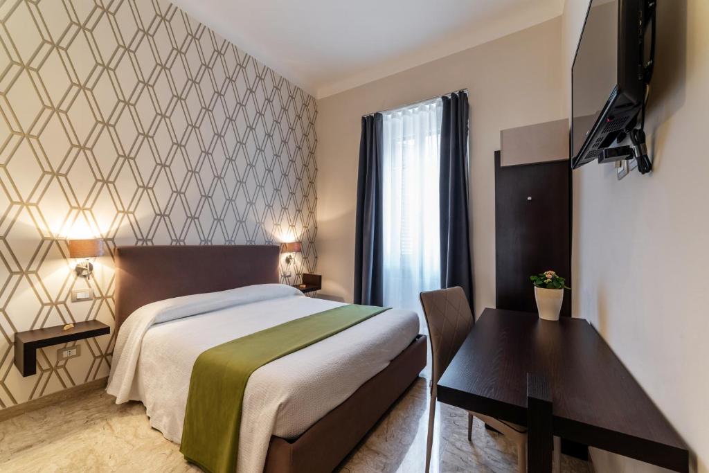 a bedroom with a bed and a table and a desk at La Rotonda da Sabrina B&B in Bari