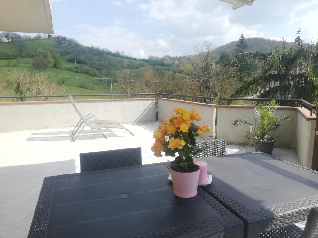 una mesa con flores en la parte superior de un balcón en La Terrazza, en Vaglia