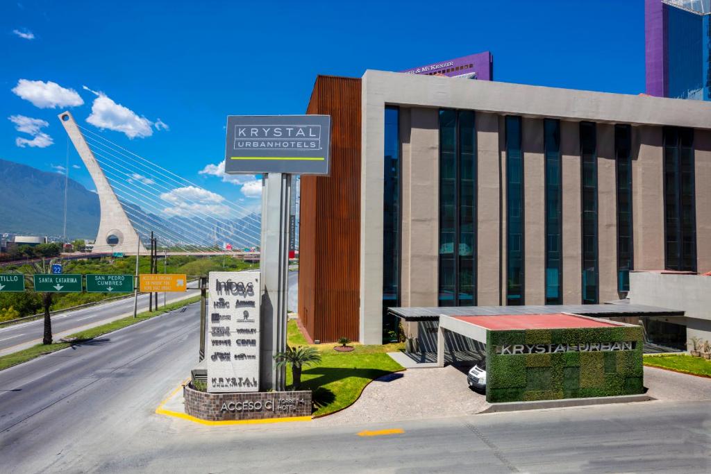 a street sign in front of a building with a bridge at Krystal Urban Monterrey San Jeronimo in Monterrey