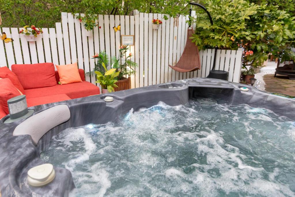 een jacuzzi in een achtertuin met een bank bij JustB Edinburgh in Edinburgh