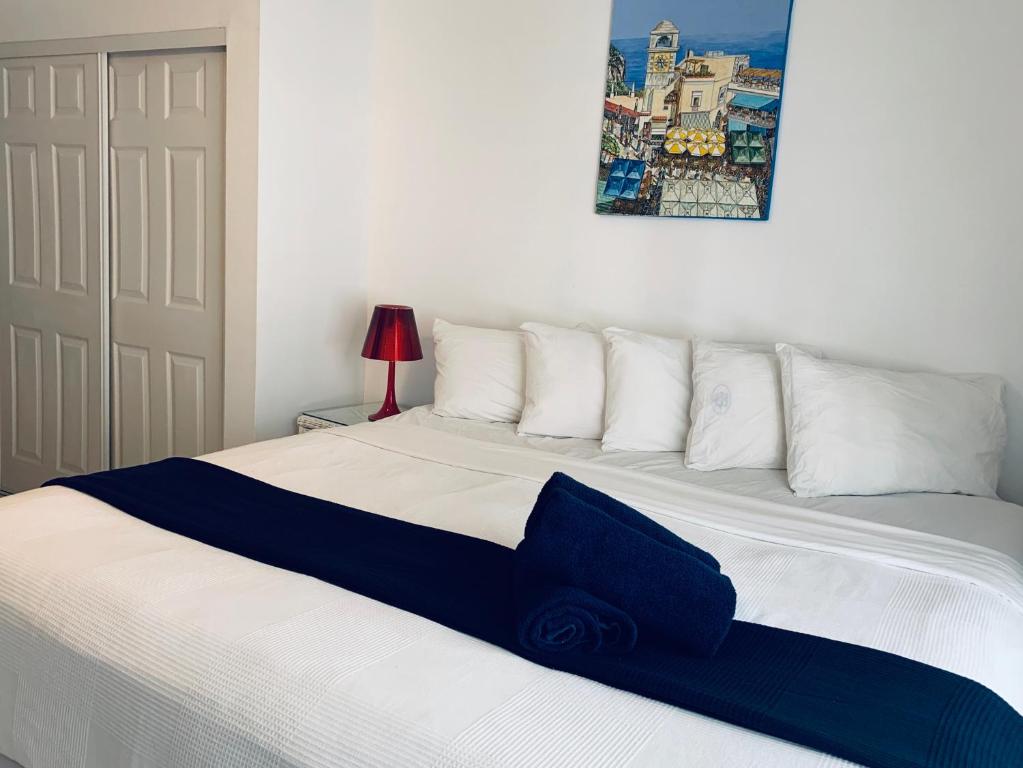 una camera da letto con un grande letto bianco con una coperta blu di Beach House BEACHFRONT STUDIO 107 a Miami Beach