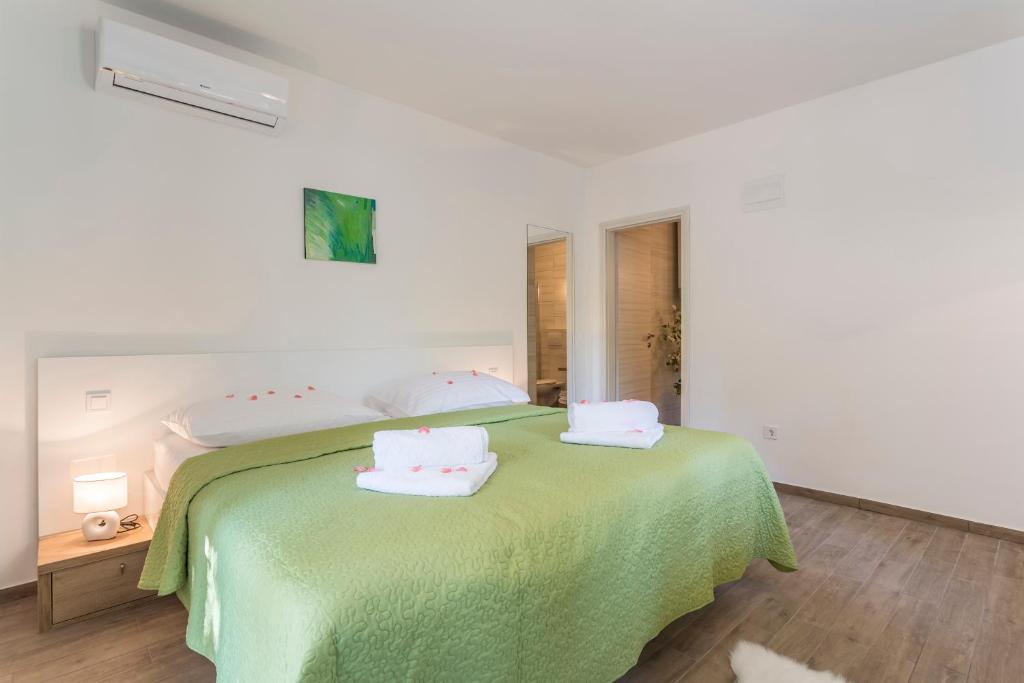 una camera da letto con un letto verde con due cuscini sopra di Maggy & Anna Apartment a Spalato (Split)