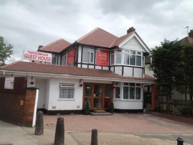 uma casa de hóspedes com um sinal em frente em Twickenham Guest House em Twickenham