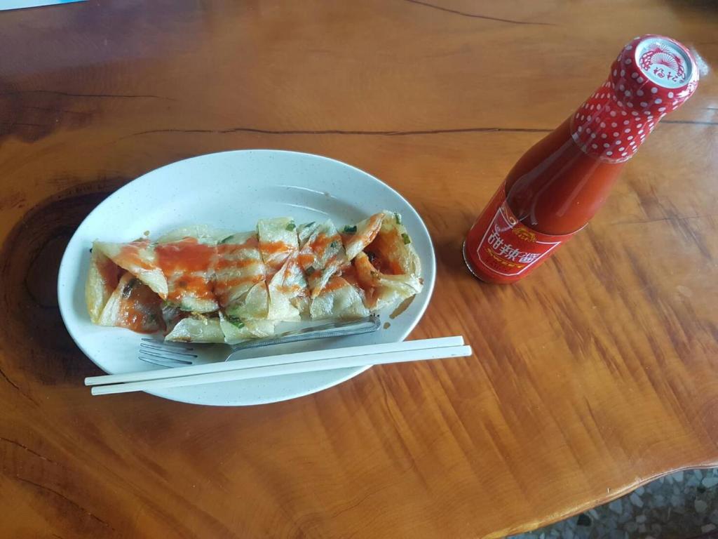 a plate of food with chopsticks and a bottle of soda at Ming Yang B&amp;B in Fenqihu
