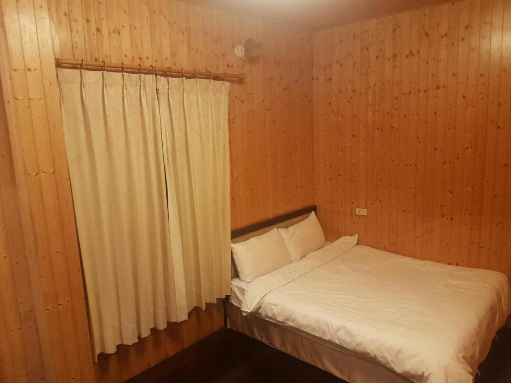 a small bedroom with a bed and a window at Ming Yang B&B in Fenqihu