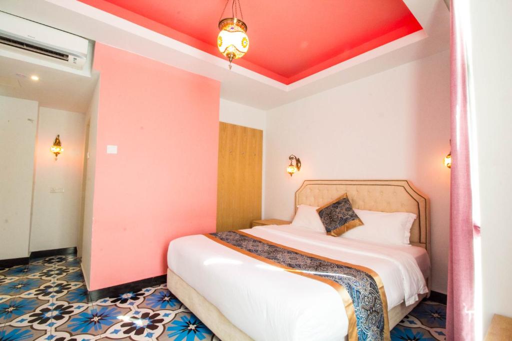 1 dormitorio con 1 cama con techo rojo en Hotel Hilal, en Cyberjaya