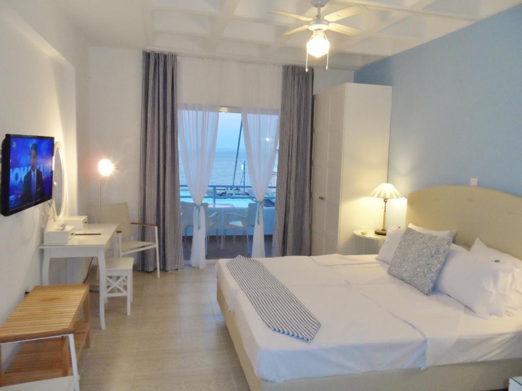 a bedroom with a bed and a room with a balcony at Seafront Studios and Apartments in Chios