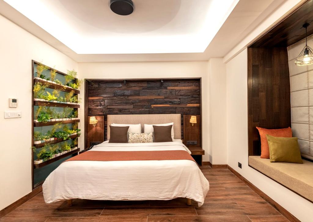 een slaapkamer met een groot bed en een houten muur bij Virohaa Hotel in New Delhi