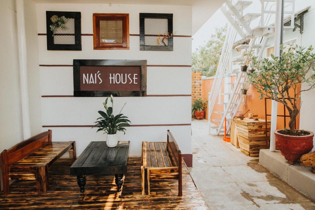 un patio con bancos y un cartel de la casa de los micrófonos en la pared en Nai's house - Homestay, en Thanh Hải