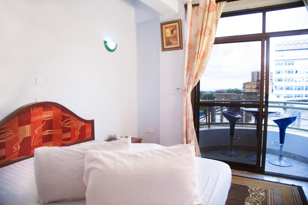 1 dormitorio con 2 camas y ventana grande en Natron Palace Hotel en Arusha