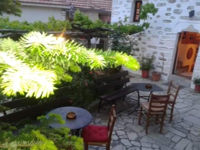 a patio with chairs and a table and some plants at Αrchontiko Tis Marios in Portariá