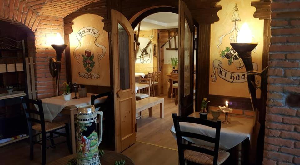 Landhotel Basler Hof في لاوترباخ: غرفة طعام مع طاولات وكراسي وجدار من الطوب