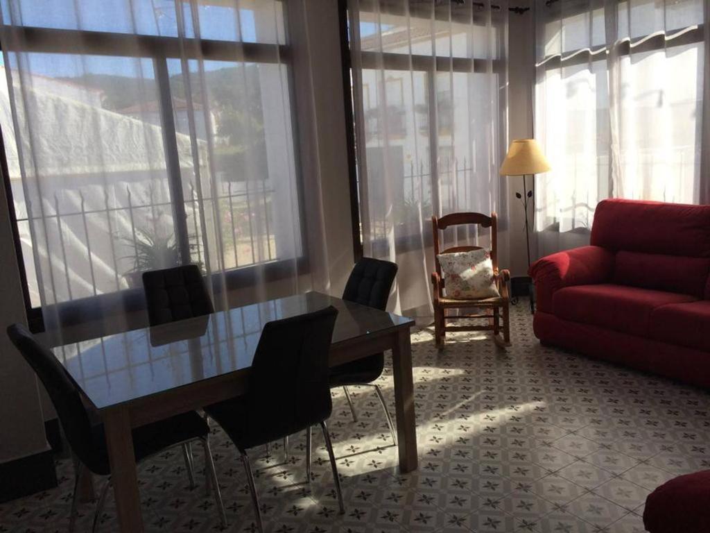 uma sala de estar com um sofá vermelho e uma mesa em La Casa de Monica em Aracena