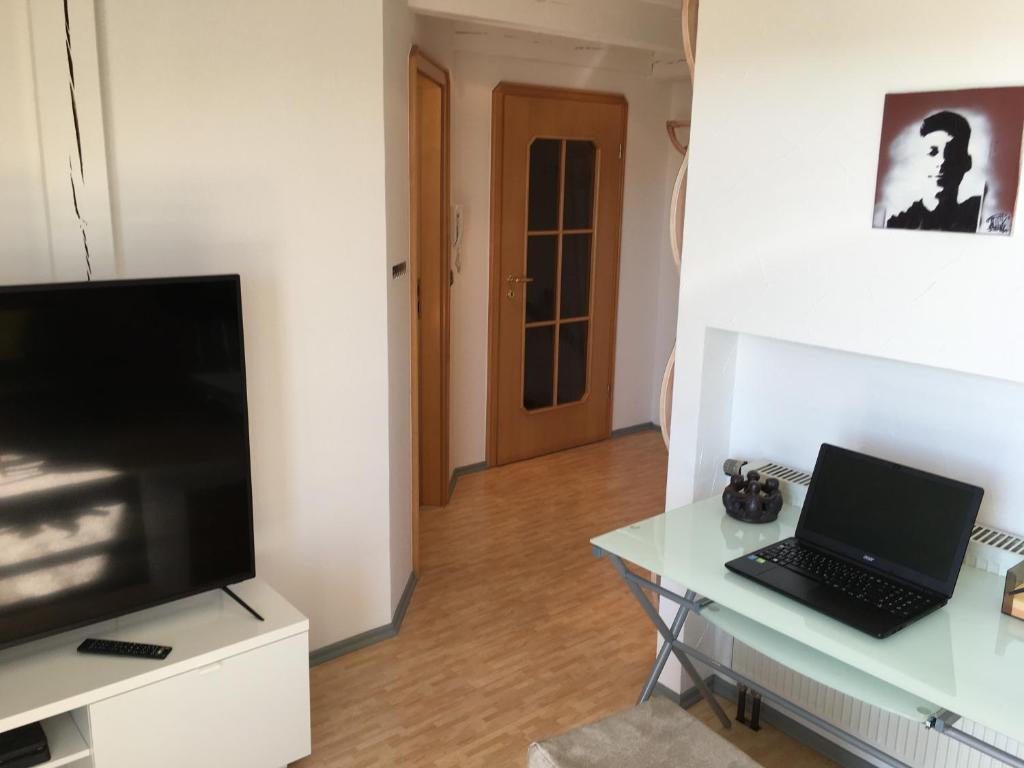 a living room with a television and a table with a laptop at Kays Home in Bad Wörishofen
