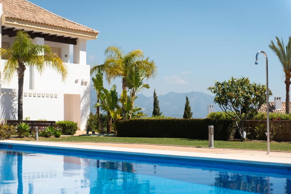 una piscina di fronte a una casa con palme di Luxury townhouse La Cala Golf Resort (Golf, Beach, Nature and Amazing views) a La Cala de Mijas