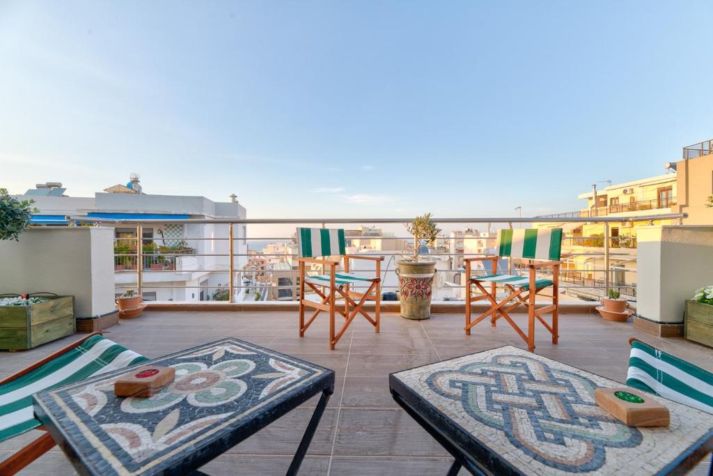 - un balcon avec des chaises et une table dans un bâtiment dans l'établissement Agios Titos Luxury Home, à Héraklion