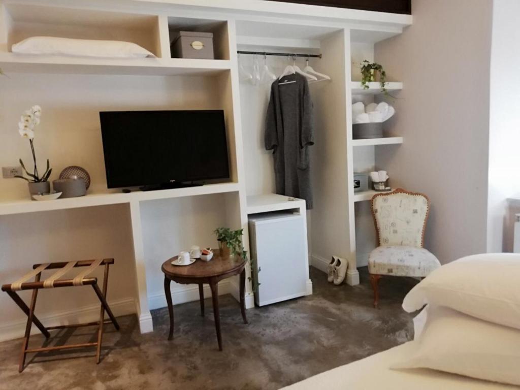 1 dormitorio con TV, mesa y silla en Affittacamere Joss, en La Spezia