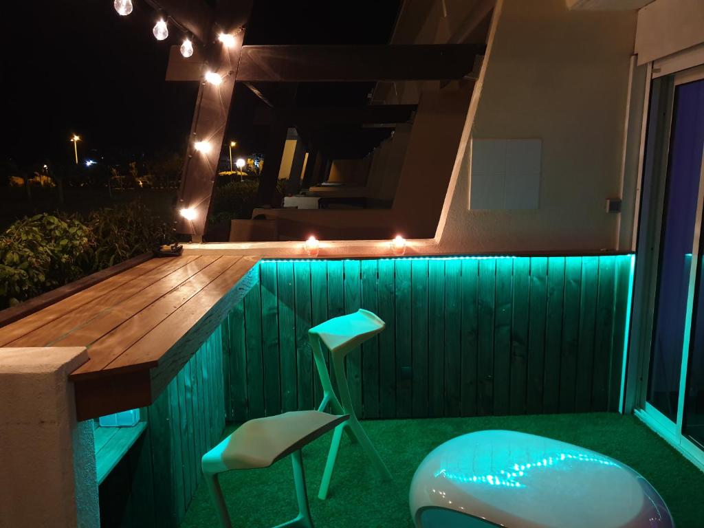 a deck with two chairs and a table with lights at Studio Naturiste P.Nature 6 in Cap d&#39;Agde