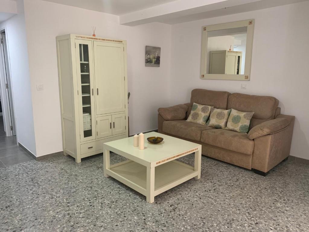 ein Wohnzimmer mit einem Sofa und einem Tisch in der Unterkunft Amate con encanto in Sevilla