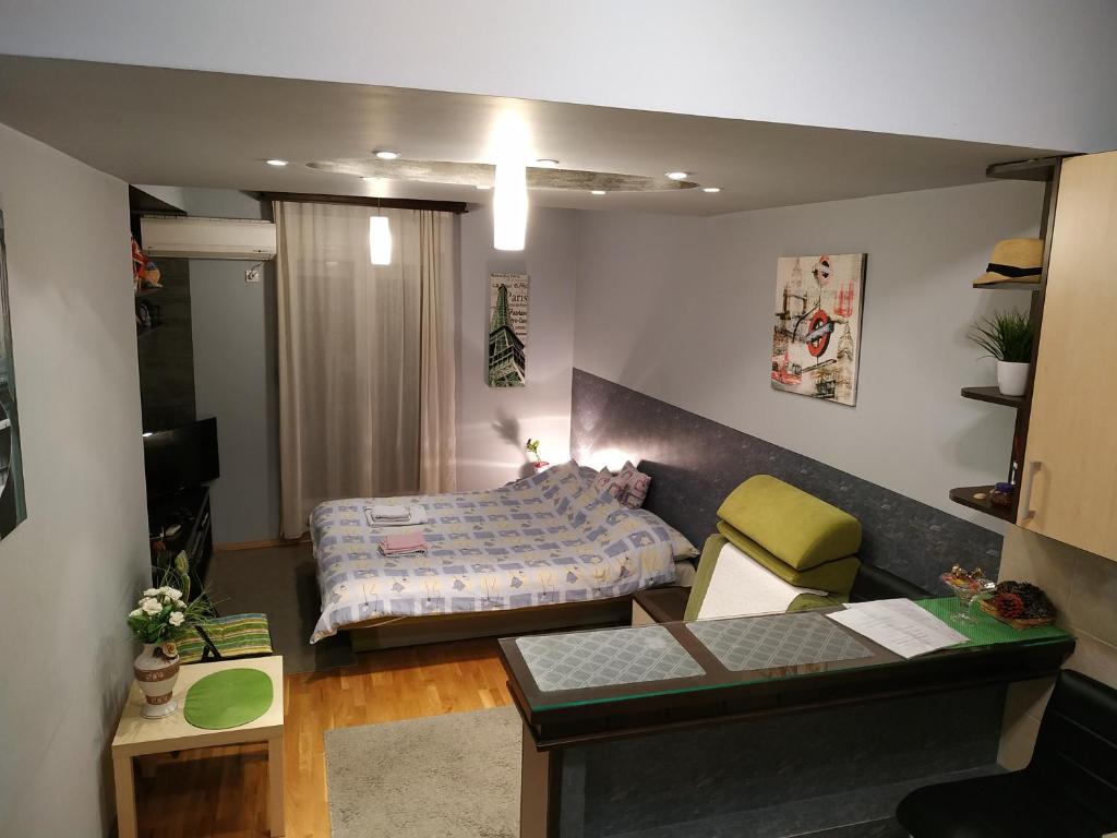 een kleine slaapkamer met een bed en een bureau bij Pg Apartment in Podgorica